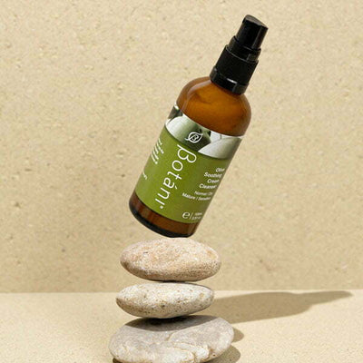 OLIVE SOOTHING CREAM CLEANSER on top of a stone